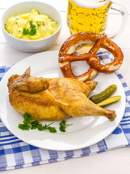 Hälften stekt kyckling, öl, kringla och potatis sallad — Stockfoto