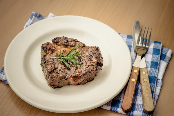 Juicy grilled rib eye steak with cutlery — Stock Photo, Image