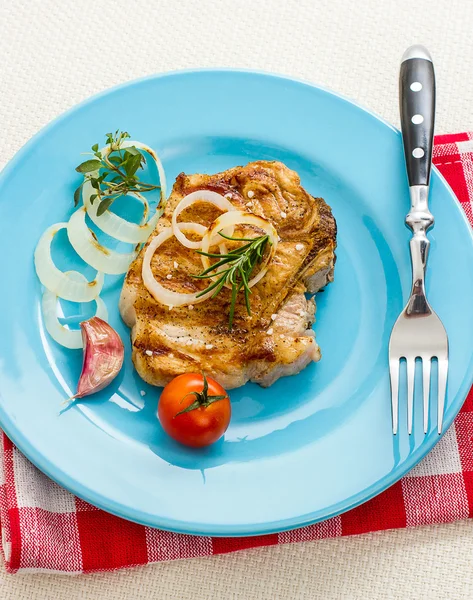 Juicy grilled pork chop, onion and tomato — Stock Photo, Image