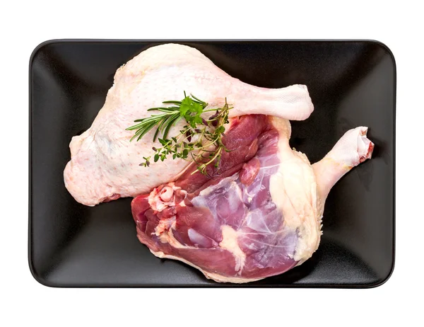 Muscovy duck leg with herb on black plate — Stock Photo, Image