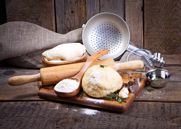 Dough with roller pin and tomatoes — Stock Photo, Image