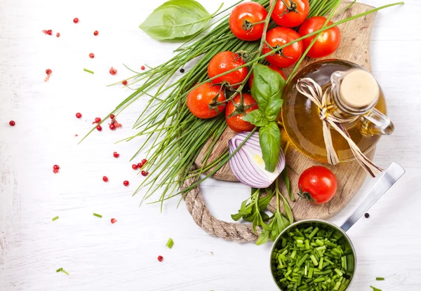 Cherry tomatoes and greens and olive oil — Stock Photo, Image