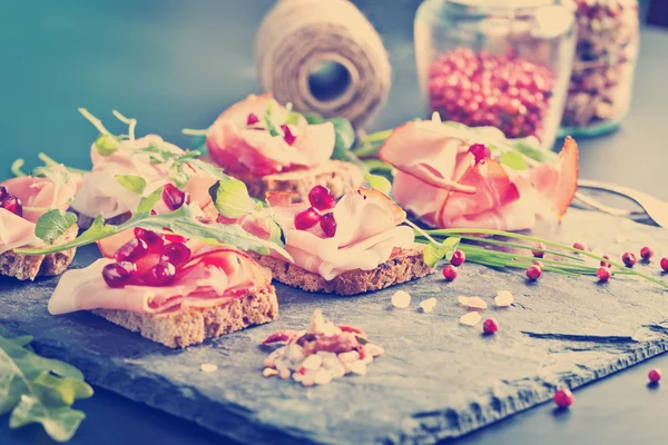 Prosciutto en rodajas con hierbas y semillas de granada — Foto de Stock