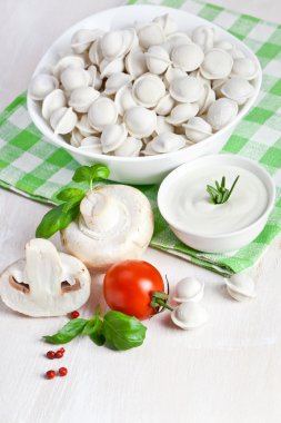 Tortellini and vegetables on white clipart