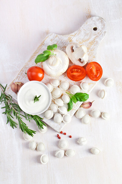 Тортеллини и овощи на белом
