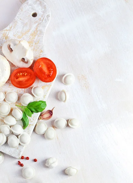 Тортеллини и овощи на белом — стоковое фото