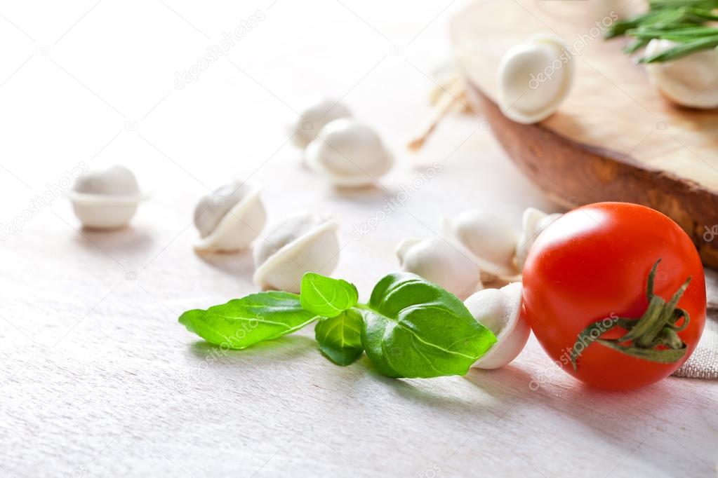 Tortellini and vegetables on white