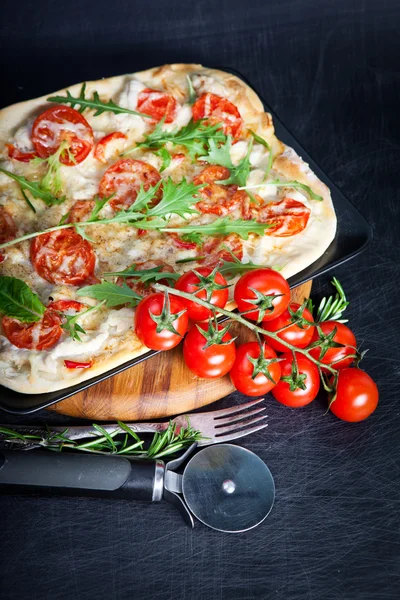 Fresh pizza on dark — Stock Photo, Image
