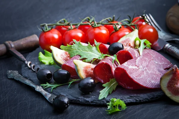 Prosciutto crudo with arugula and figs — Stock Photo, Image