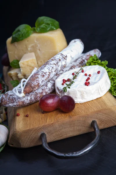 Various cheeses and salami — Stock Photo, Image