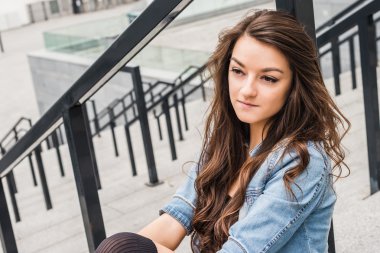 Açık havada merdivenlerde oturan kadın