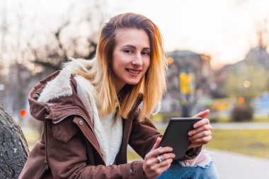 Tablet açık gülümseyen kullanan genç kadın.