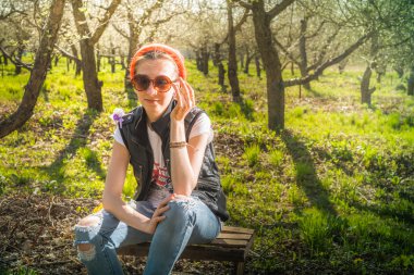 Bahçede elma ağacının yakınında duran güzel genç sarışın kadın 
