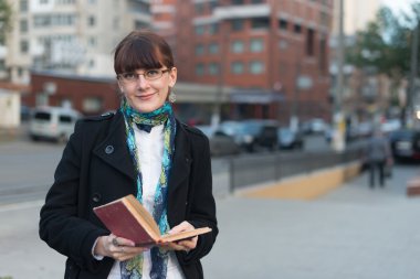 Genç kadın şehirde bir kitap okuma