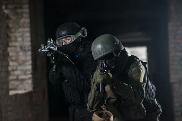 Voll ausgerüstete Militärs mit automatischen Waffen, die Airsoft Strikeball spielen — Stockfoto