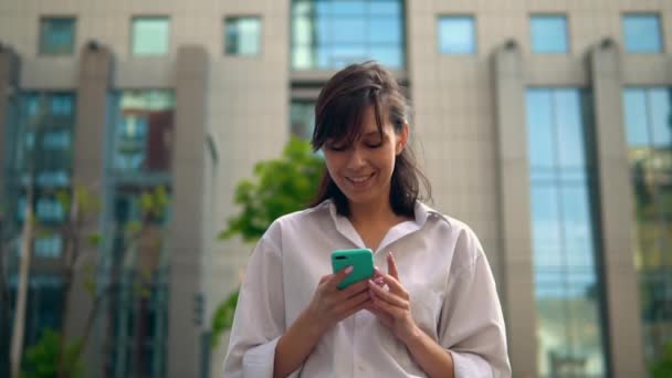 Säker affärskvinna använder smartphone promenader i staden — Stockvideo