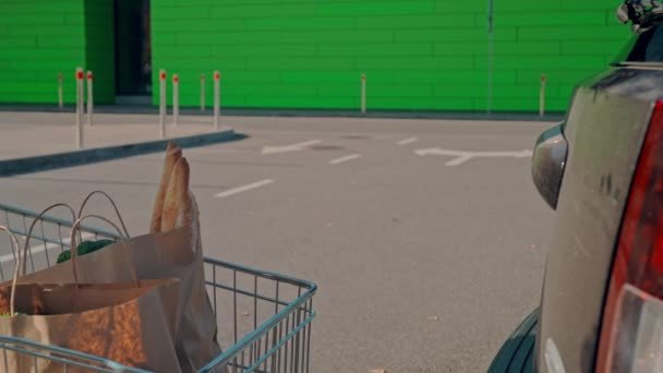 Kille med kundvagn nära butik — Stockvideo