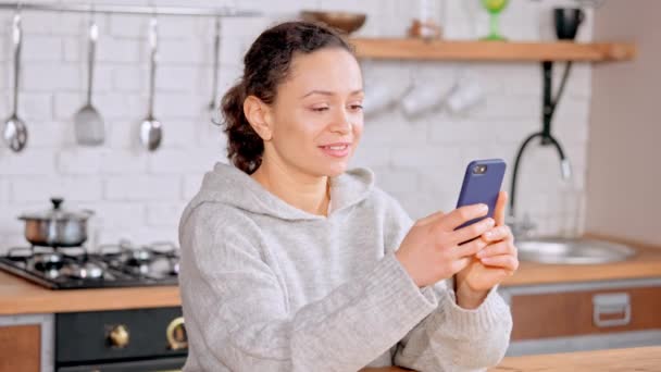 Weibchen mit Handy in der Küche — Stockvideo