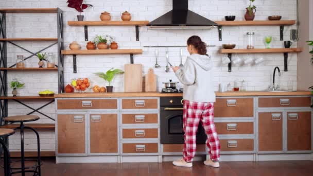 Huisvrouw met apparaat op de keuken — Stockvideo