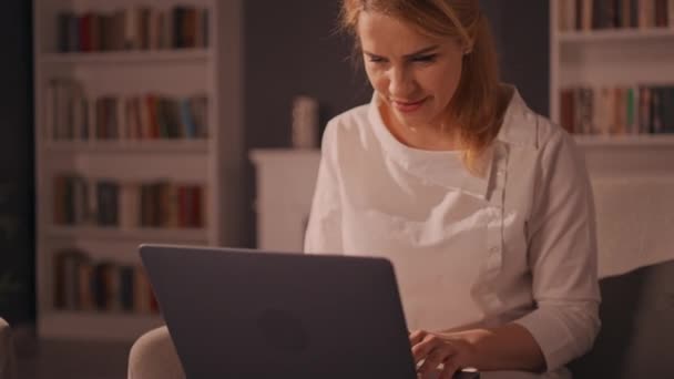 Blonde femelle en utilisant l'ordinateur dans l'appartement — Video