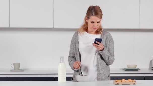 Blondýny pomocí mobilní ráno v kuchyni — Stock video