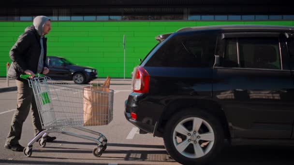 Man with shopping cart near store — Stock Video