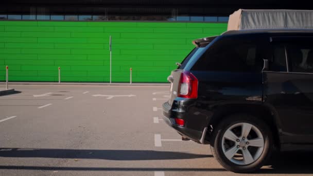 Volwassen blanke vrouw op parkeerplaats in de buurt van winkel — Stockvideo