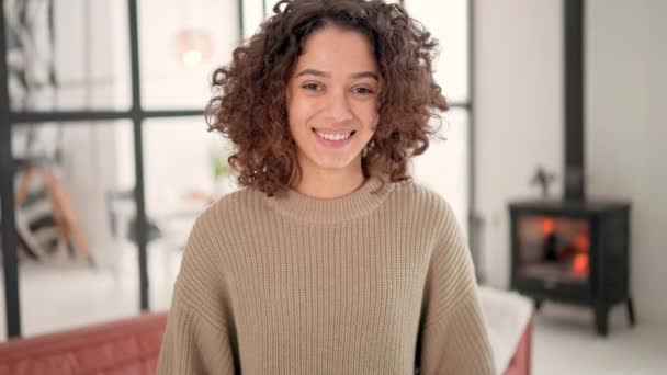 Glimlachende jonge brunette met krullend haar poseren — Stockvideo