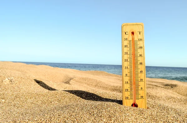 Термометр на песчаном пляже — стоковое фото