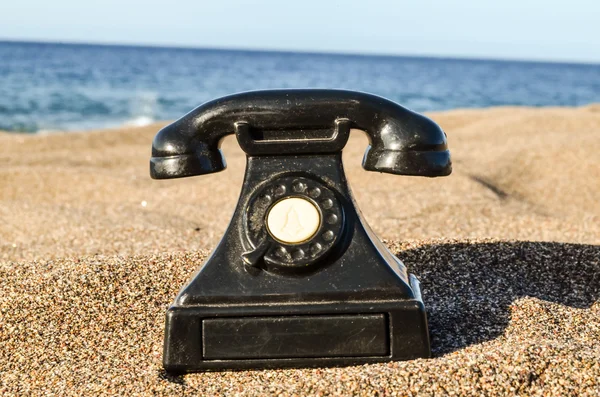 Teléfono en la playa de arena — Foto de Stock