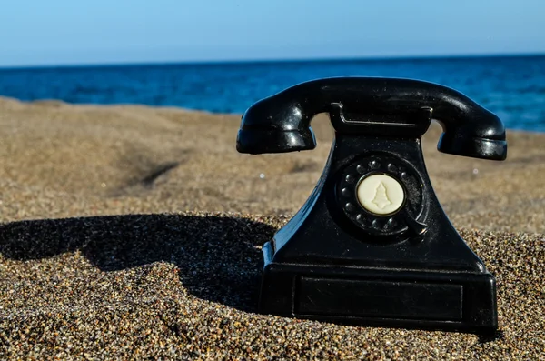 Teléfono en la playa de arena — Foto de Stock