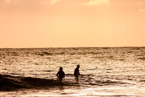 Surfista ao pôr-do-sol num oceano calmo — Fotografia de Stock