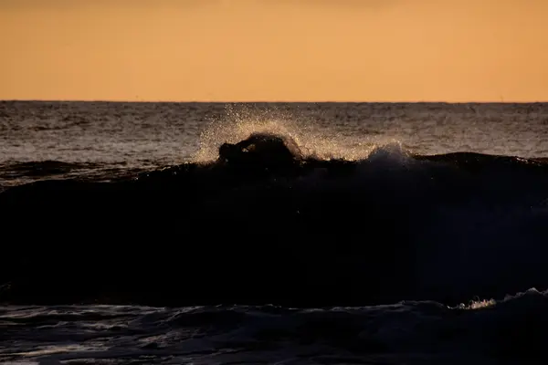 Surfer bij zonsondergang op een rustige oceaan — Stockfoto