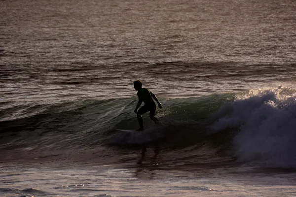Surfer o zachodzie słońca na spokojnym oceanie — Zdjęcie stockowe