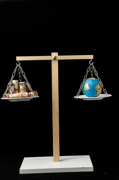 Ziemia i pieniądze na dwóch Pan Balance — Zdjęcie stockowe