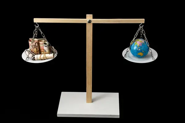 Earth and Money on a Two Pan Balance — Stock Photo, Image