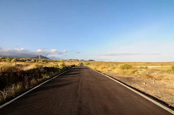 Pitkä tyhjä Desert Road — kuvapankkivalokuva