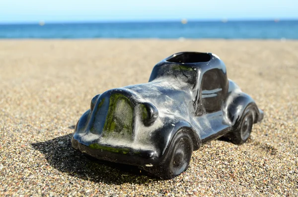 Coche de juguete en la orilla del mar — Foto de Stock