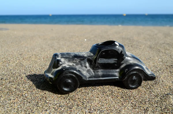 Coche de juguete en la orilla del mar —  Fotos de Stock