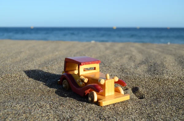 Coche de juguete en la orilla del mar — Foto de Stock
