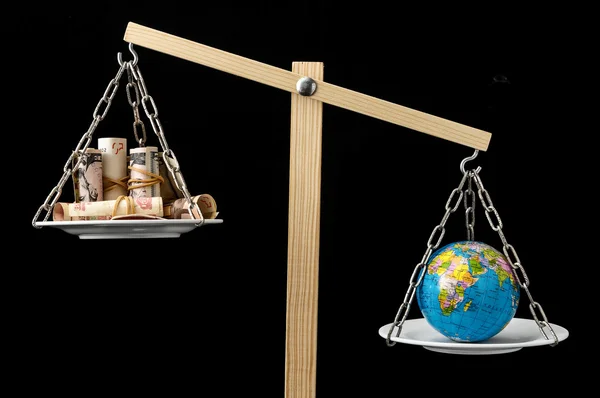 Earth and Money on a Two Pan Balance — Stock Photo, Image