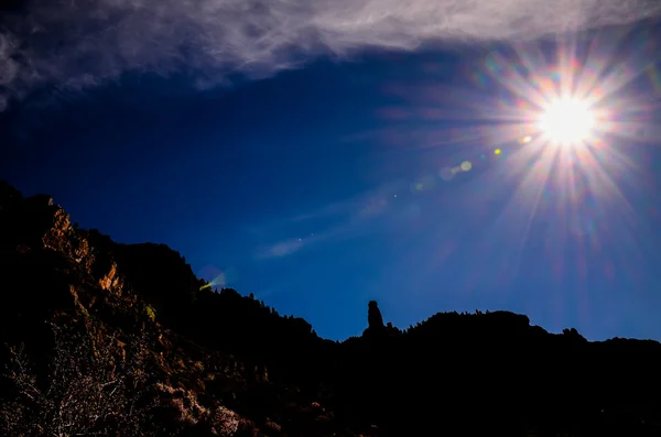 Sun Star na modrou oblohu nad siluetu hory — Stock fotografie
