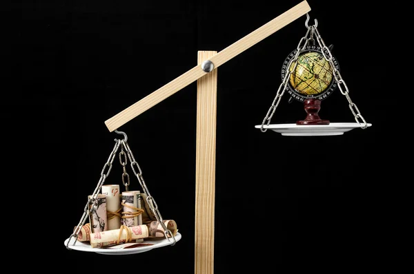 Earth and Money on a Two Pan Balance — Stock Photo, Image