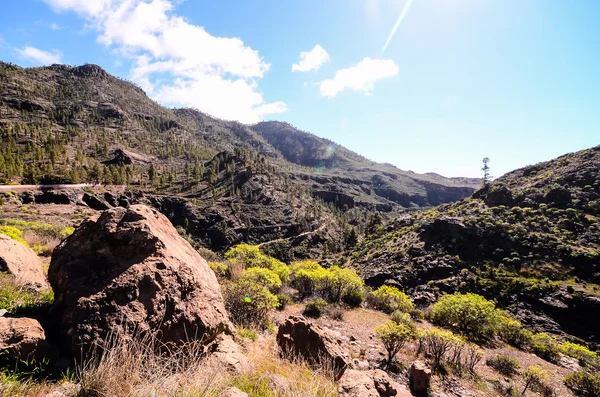 Sol estrella en un cielo azul sobre una silueta de montaña —  Fotos de Stock