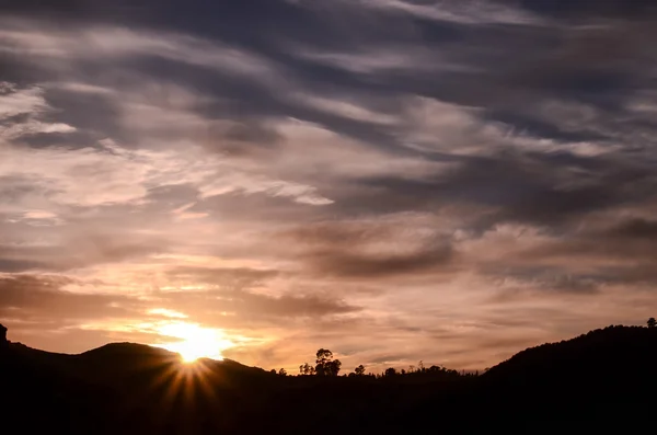 Soleil derrière une silhouette de montagne — Photo