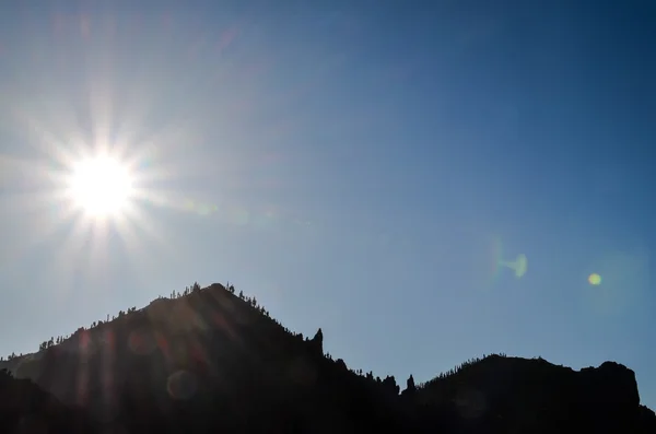 Sun Star na niebieski niebo nad sylwetka Mountain — Zdjęcie stockowe