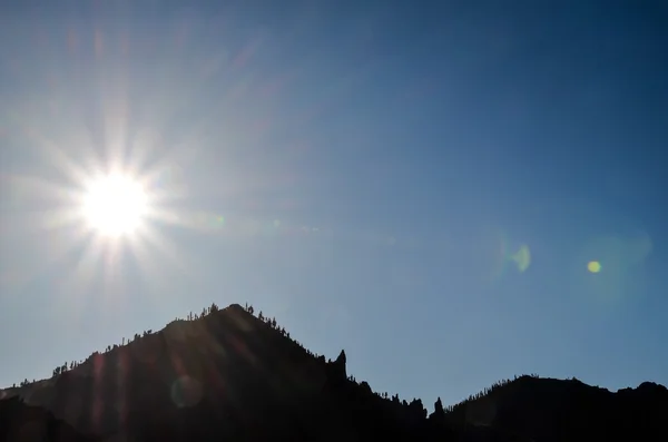 Sun Star na niebieski niebo nad sylwetka Mountain — Zdjęcie stockowe