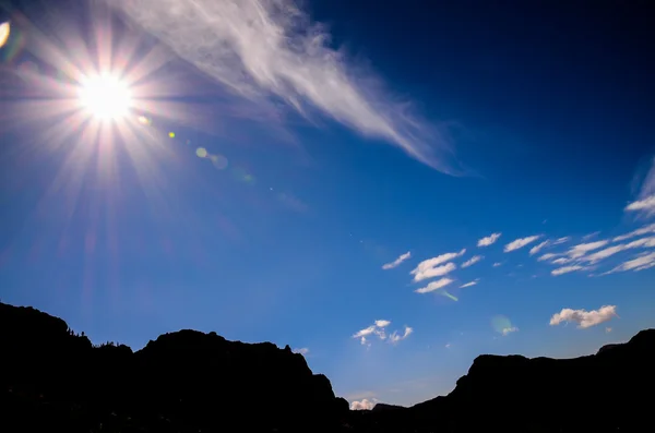 Bir dağ silueti üzerinde mavi bir gökyüzü güneş Star'da — Stok fotoğraf