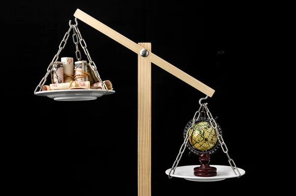 Earth and Money on a Two Pan Balance — Stock Photo, Image