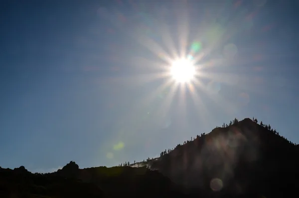 Sun Star na niebieski niebo nad sylwetka Mountain — Zdjęcie stockowe